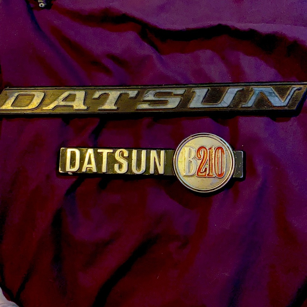 TWO DATSUN PLASTIC CAR EMBLUMS